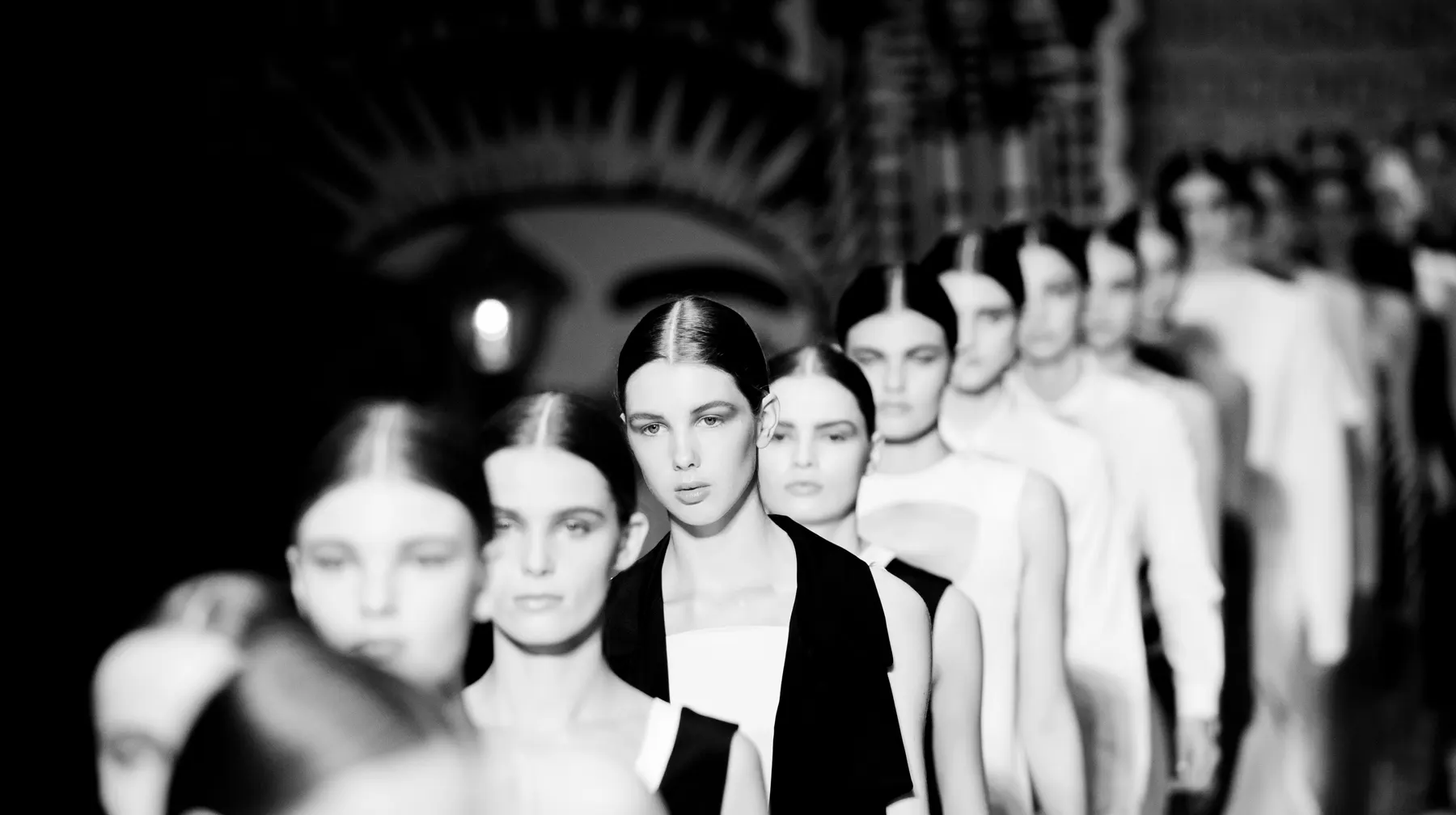 Monochrome runway lineup at a fashion presentation.